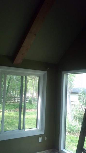 Freshly painted ceiling, walls, trim, and mouldings. Wood ceiling beams are stained.
